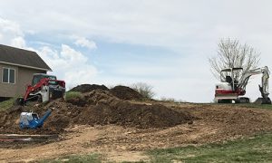 Two takeuchi machines being used on a residential job site