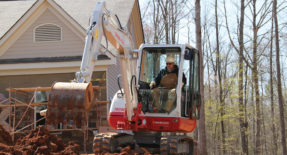 TB240 being used to dig up dirt in front of home