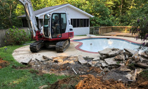 Takeuchi Excavator removing concrete around pool