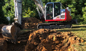 Takeuchi Excavator digging dirt to create opening for a pool